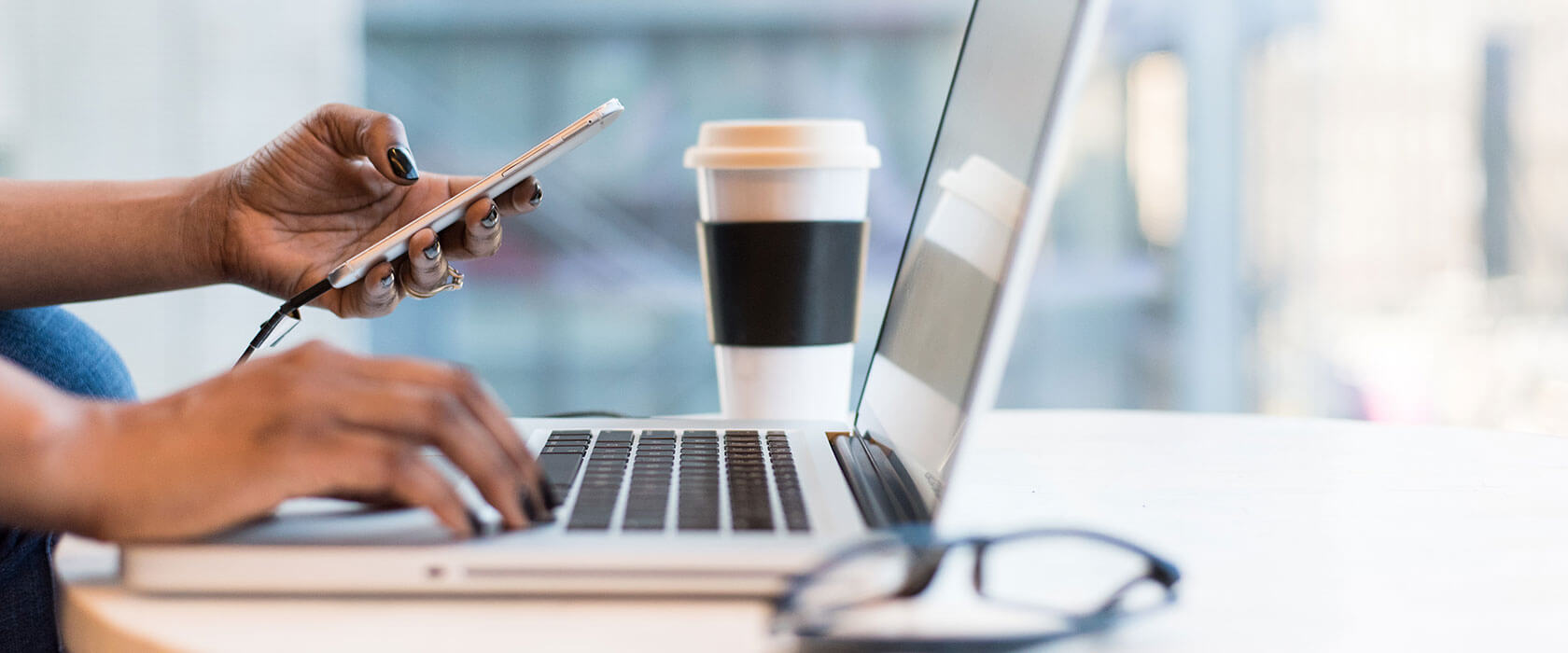 someone working on their laptop with a coffee next to them